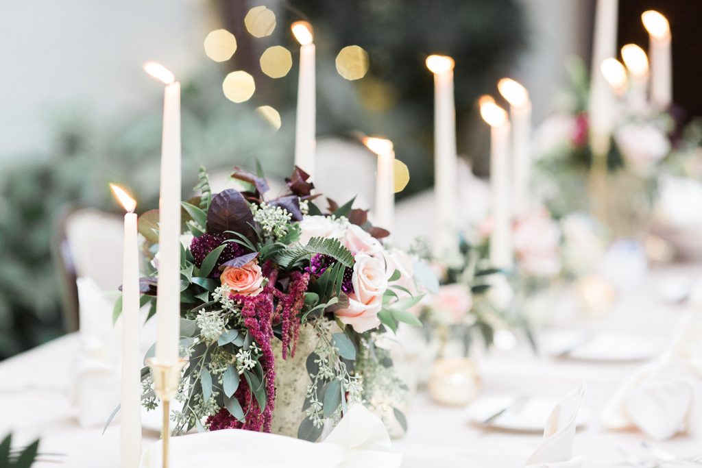 wedding reception long guest table with low centerpieces candlesticks