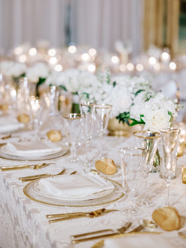 wedding reception guest banquet table low centerpieces gold compote white flowers greenery