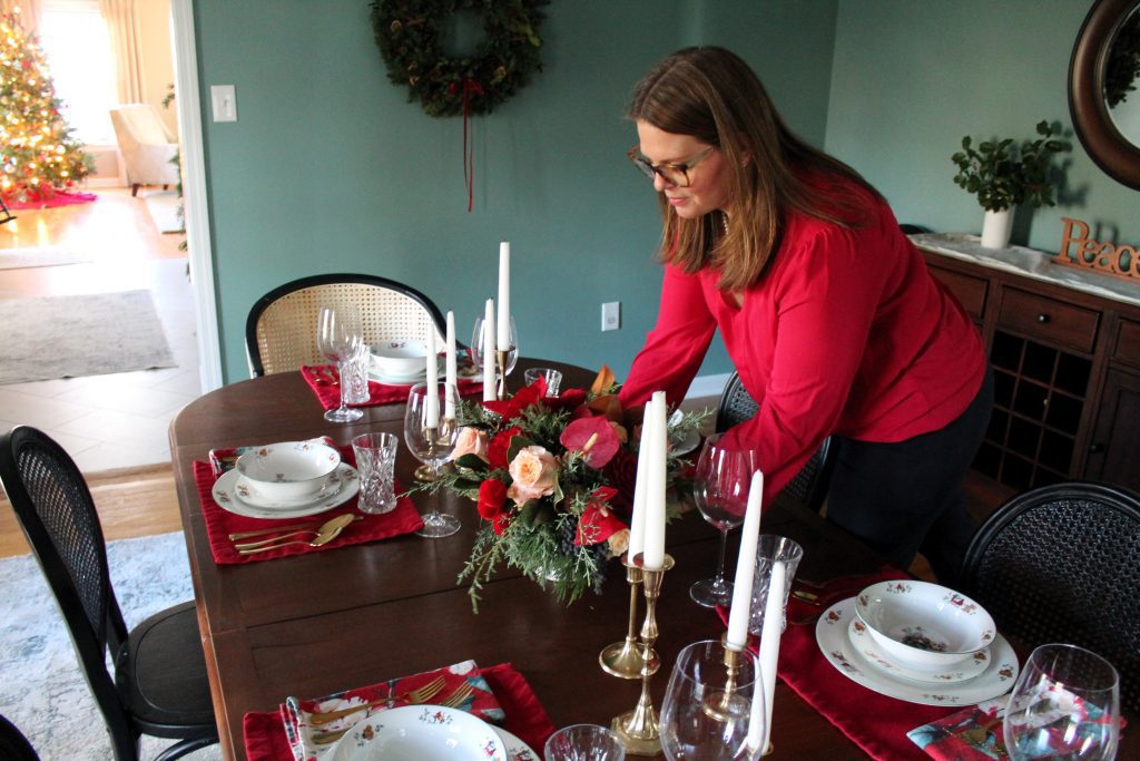 placing the Christmas floral centerpiece on the table